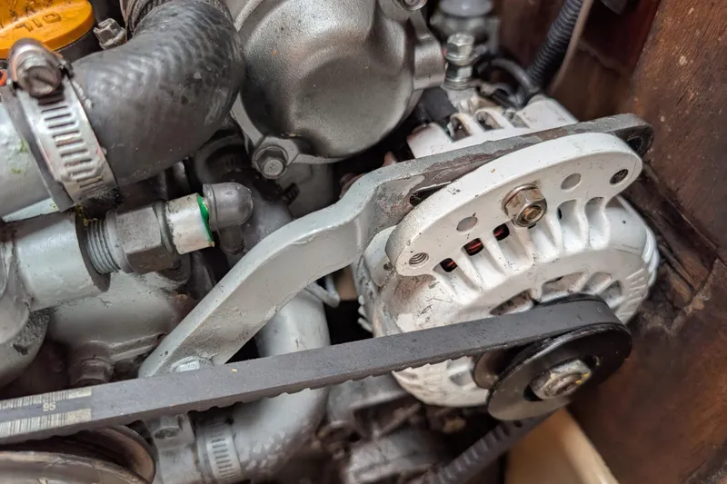 Slide: The Image of Engine components of a 1988 Island Packet 38 sailboat, featuring alternator and belt system. - 56