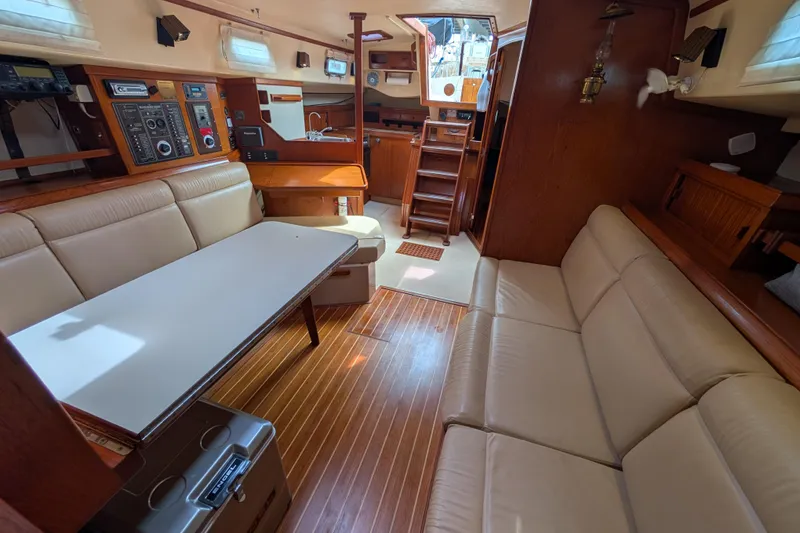 Slide: The Image of Interior of a 1988 Island Packet 38 sailboat with beige seating and wooden accents. - 6