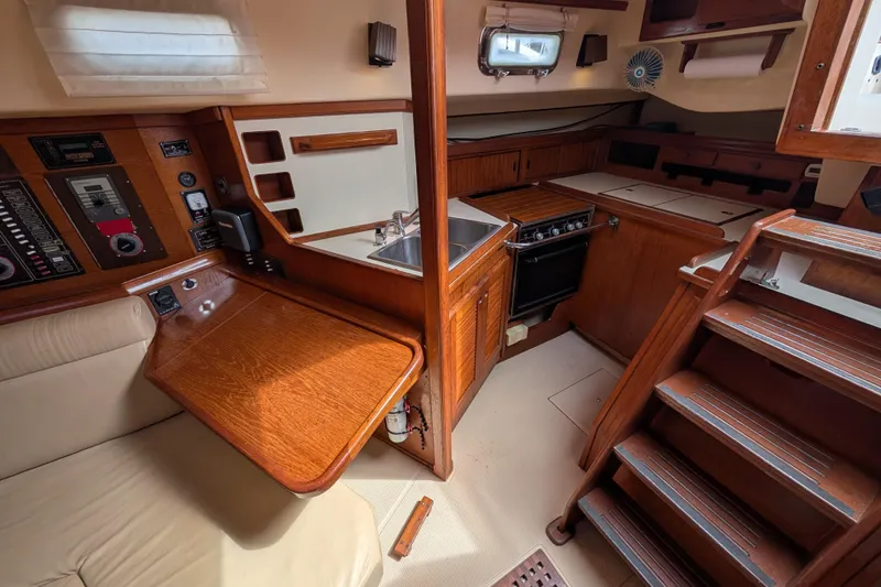 Slide: The Image of 1988 Island Packet 38 interior with wooden cabinetry, kitchen, and navigation station. - 7