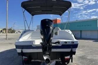 Slide: The Image of 2022 Hurricane SunDeck Sport 192 RL OB boat with outboard motor, docked under clear sky. - 4