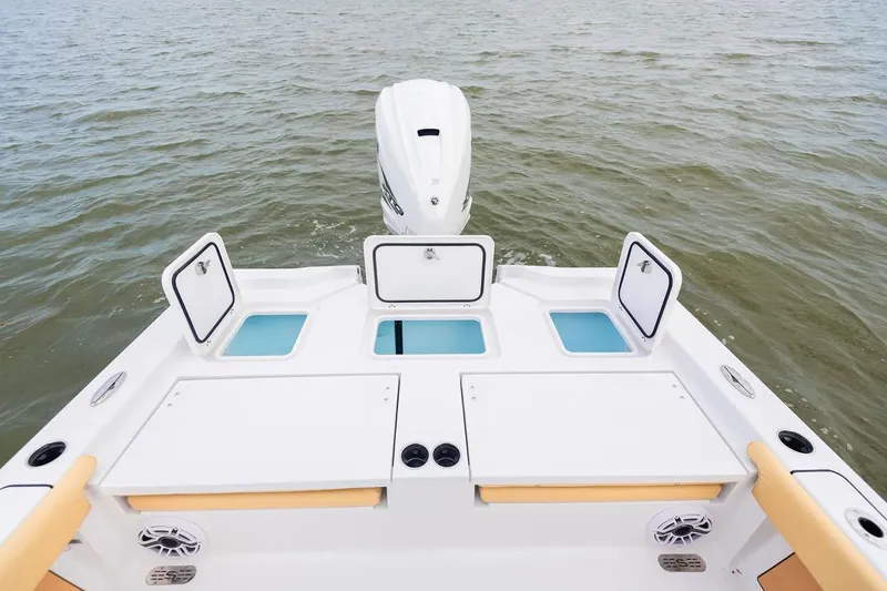 Slide: The Image of Manufacturer Provided Image: 2025 Sportsman Masters 267 Bay Boat on water, showcasing rear deck and storage compartments. - 8