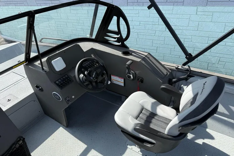 Slide: The Image of 2026 SeaArk Protege 200 boat interior with steering wheel and captain's chair. - 11