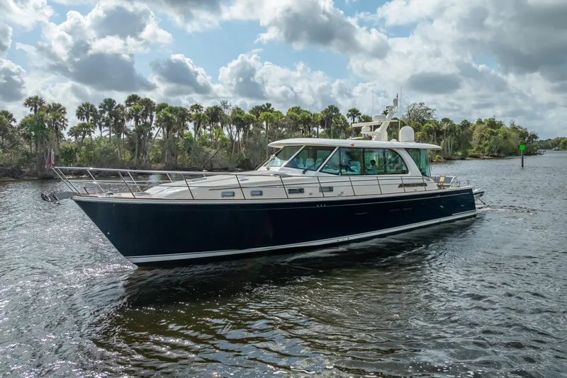 The Image of 2025 Sabre 58 Salon Express yacht cruising on a scenic waterway. - 1