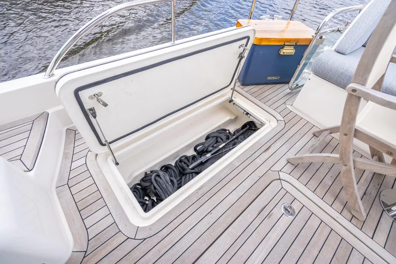 Slide: The Image of 2025 Sabre 58 Salon Express deck with open storage compartment and ropes. - 10