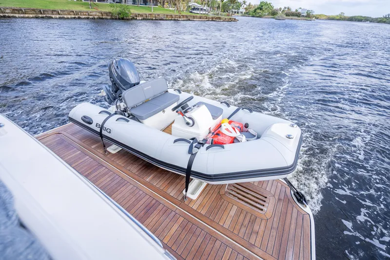 Slide: The Image of 2025 Sabre 58 Salon Express with inflatable boat on wooden deck by the water. - 12