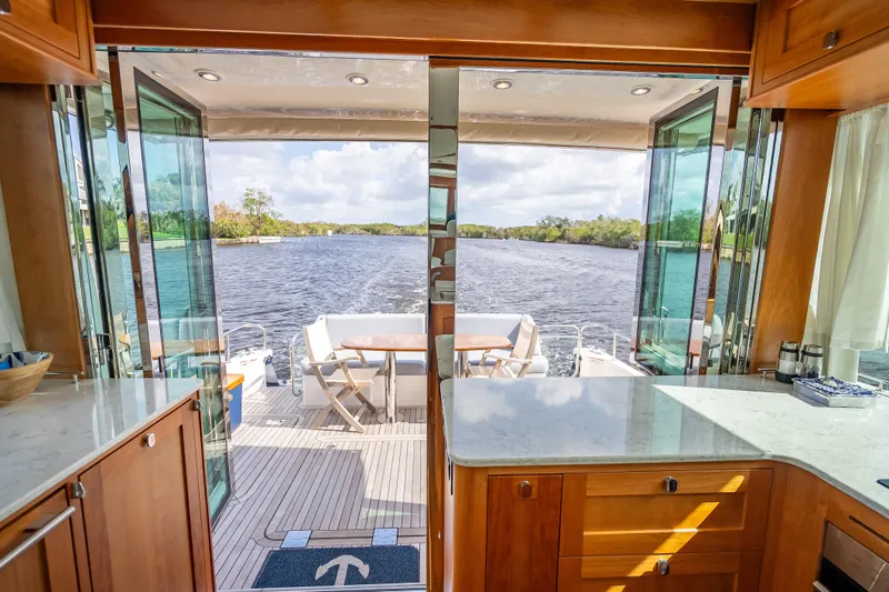 Slide: The Image of Interior view of 2025 Sabre 58 Salon Express yacht with open deck and river scenery. - 17