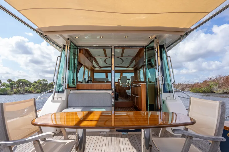 Slide: The Image of 2025 Sabre 58 Salon Express yacht interior with elegant seating and wooden table. - 3