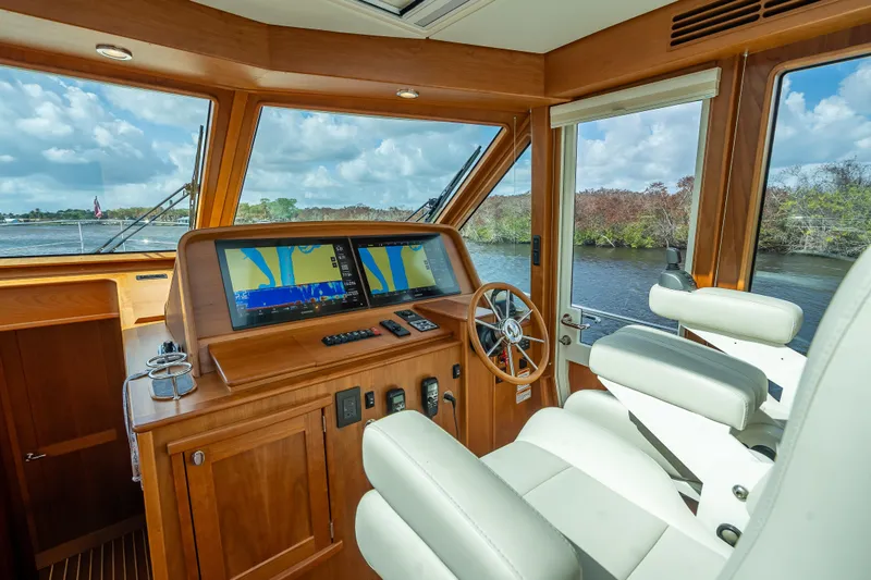 Slide: The Image of 2025 Sabre 58 Salon Express helm with navigation screens and luxurious seating. - 34