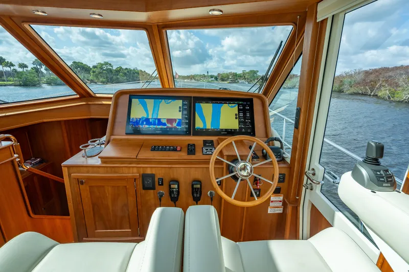 Slide: The Image of 2025 Sabre 58 Salon Express helm with navigation screens and wooden steering wheel. - 35