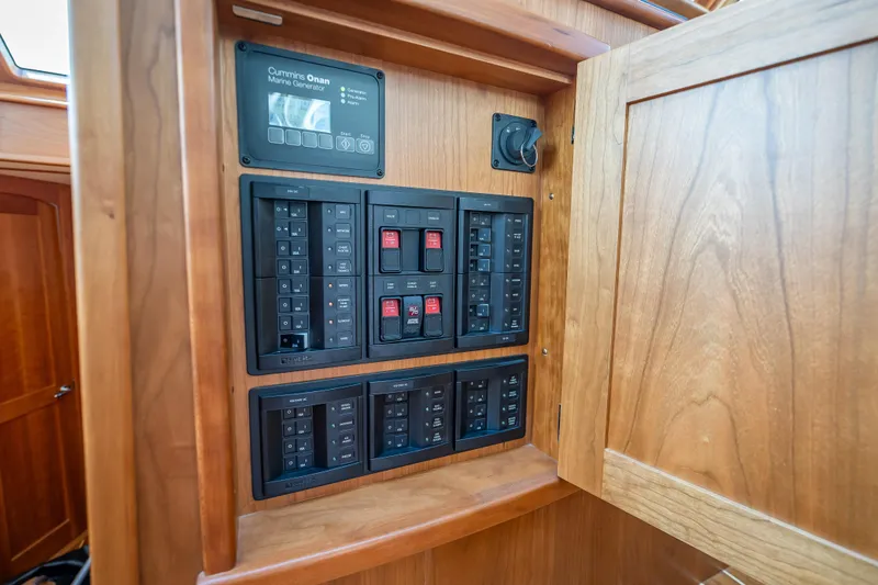 Slide: The Image of Electrical panel inside 2025 Sabre 58 Salon Express yacht, featuring Cummins Onan marine generator controls. - 37