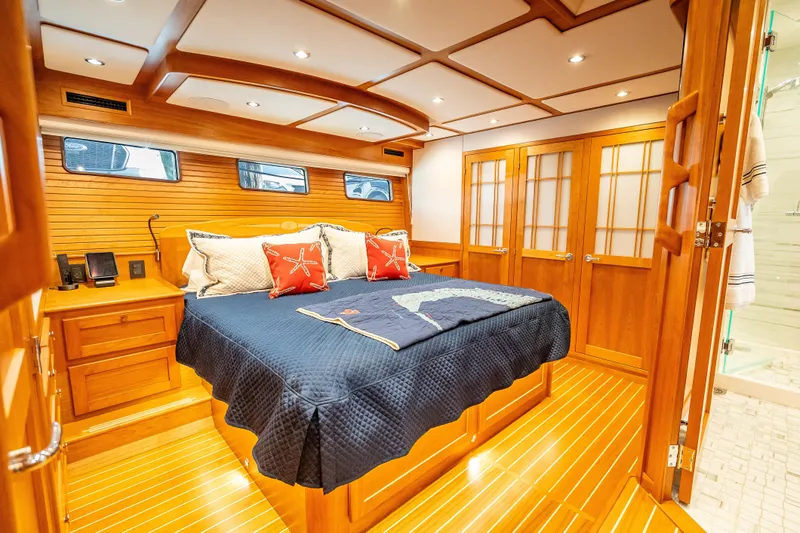 Slide: The Image of Luxurious 2025 Sabre 58 Salon Express yacht bedroom with elegant wood finish and cozy bedding. - 39