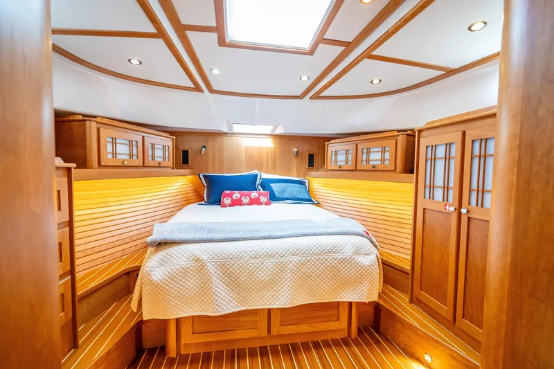 Slide: The Image of Luxurious 2025 Sabre 58 Salon Express yacht bedroom with wood paneling and skylight. - 48
