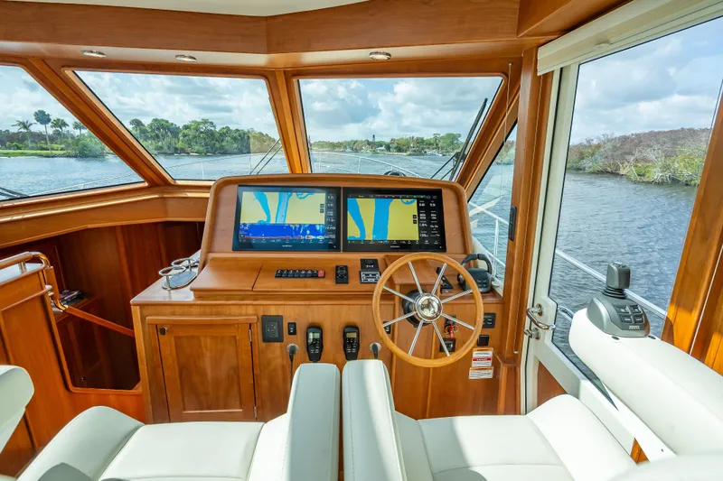 Slide: The Image of Interior helm of 2025 Sabre 58 Salon Express yacht with navigation screens and wooden steering wheel. - 5