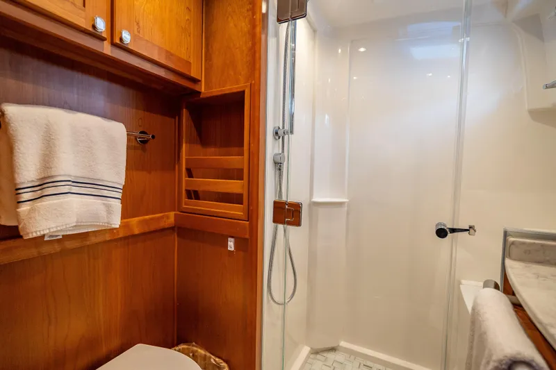 Slide: The Image of Luxurious bathroom in 2025 Sabre 58 Salon Express yacht with wooden cabinetry and glass shower. - 54