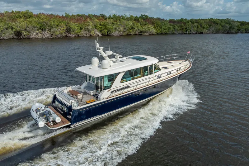 Slide: The Image of 2025 Sabre 58 Salon Express yacht cruising on a scenic river. - 6