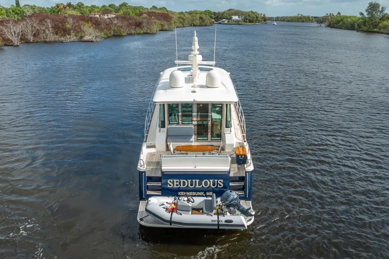 Slide: The Image of 2025 Sabre 58 Salon Express yacht cruising on a scenic river. - 68