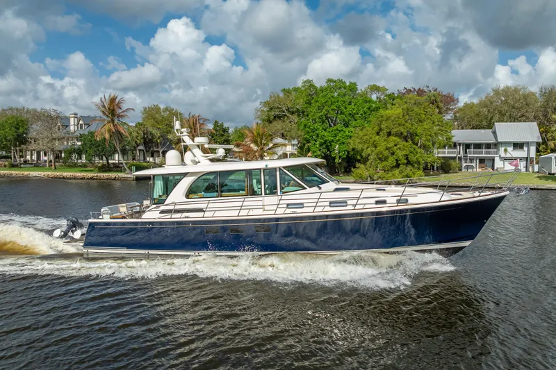 Slide: The Image of 2025 Sabre 58 Salon Express yacht cruising on a scenic waterway. - 69