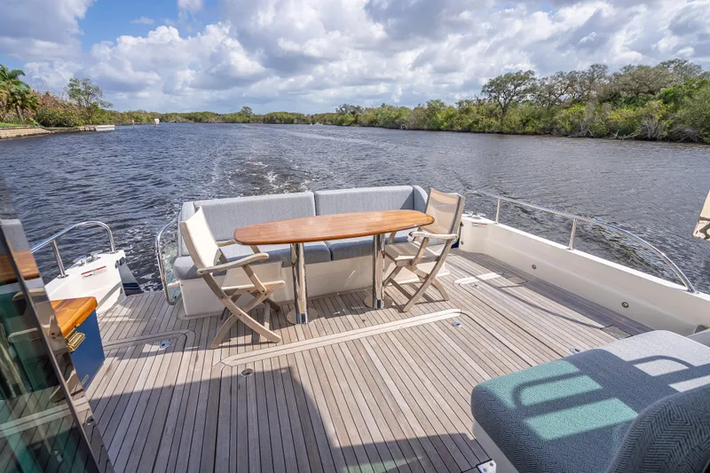 Slide: The Image of Spacious deck of 2025 Sabre 58 Salon Express yacht cruising on a scenic river. - 8