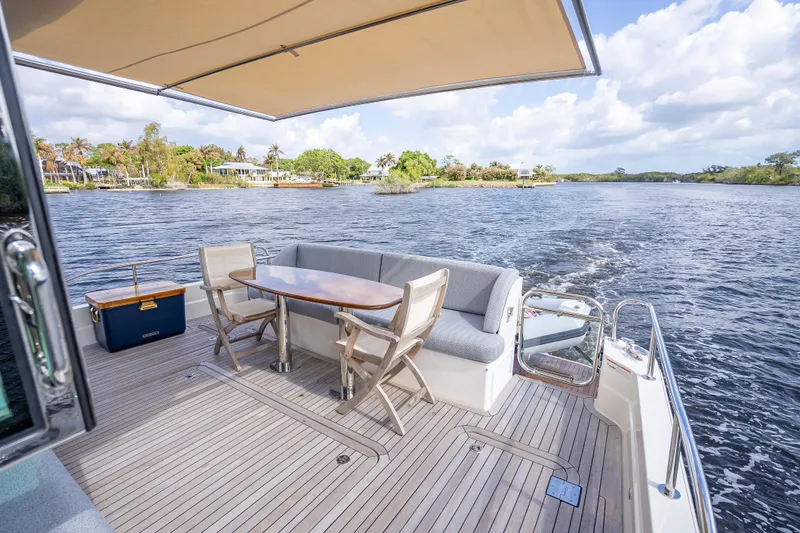 Slide: The Image of Luxurious 2025 Sabre 58 Salon Express yacht deck with seating and scenic water view. - 9