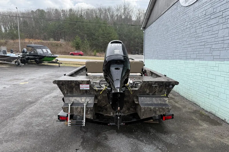 Slide: The Image of 2026 SeaArk Phantom 20XV boat with outboard motor, parked outdoors near a building. - 4