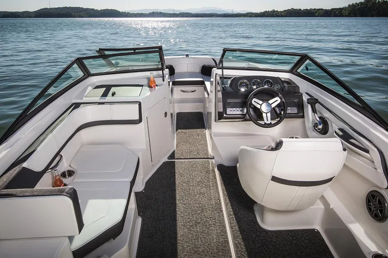 Slide: The Image of Manufacturer Provided Image: 2018 Sea Ray SPX 190 OB boat interior with seating and steering wheel on a lake. - 2