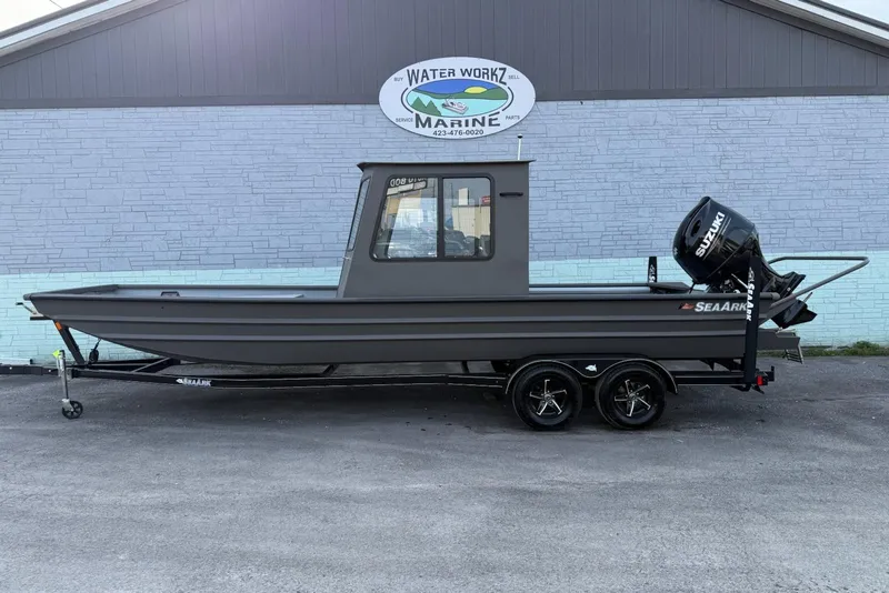 The Image of 2026 SeaArk 2472 CUB boat with Suzuki motor on trailer, parked outside Water Workz Marine. - 1