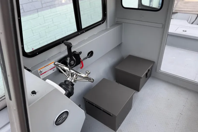 Slide: The Image of Interior of 2026 SeaArk 2472 CUB boat with steering wheel and storage compartments. - 12