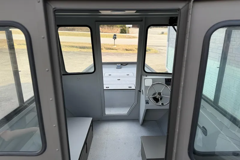 Slide: The Image of Interior of 2026 SeaArk 2472 CUB boat, featuring steering wheel and seating. - 13