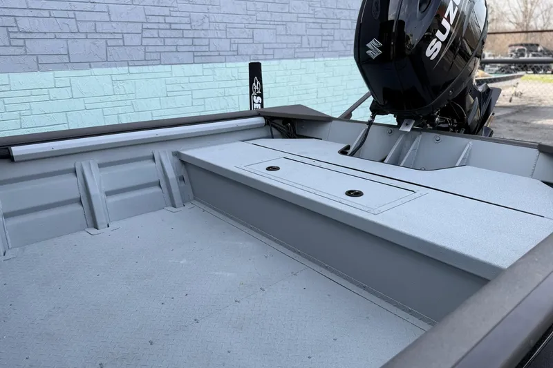 Slide: The Image of 2026 SeaArk 2472 CUB boat interior with Suzuki outboard motor, against brick wall background. - 6