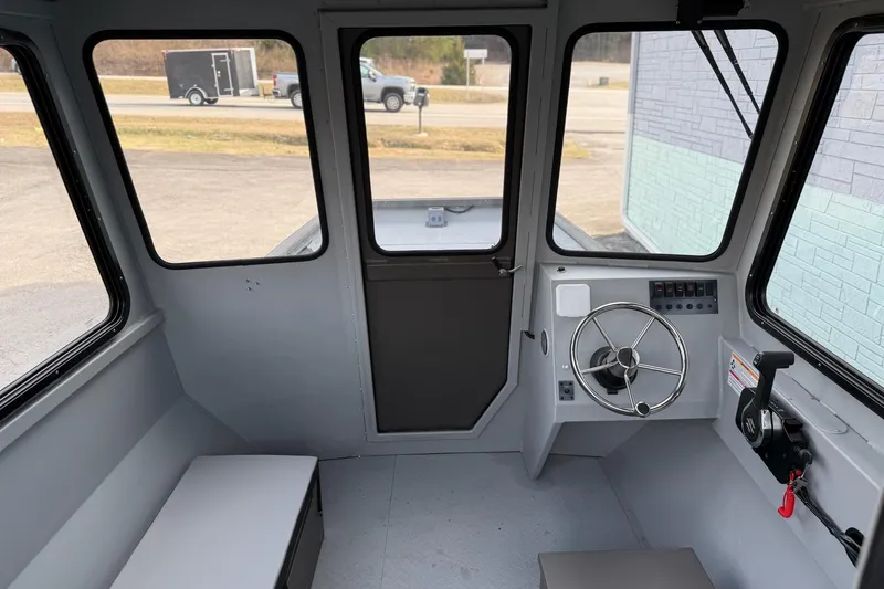 Slide: The Image of Interior of 2026 SeaArk 2472 CUB boat, featuring steering wheel and control panel. - 8