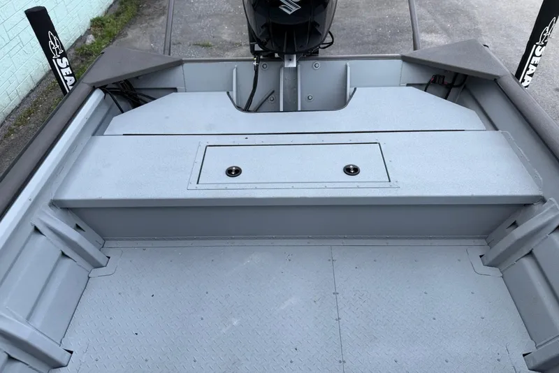 Slide: The Image of 2026 SeaArk 2472 CUB boat interior with storage compartment and motor. - 9