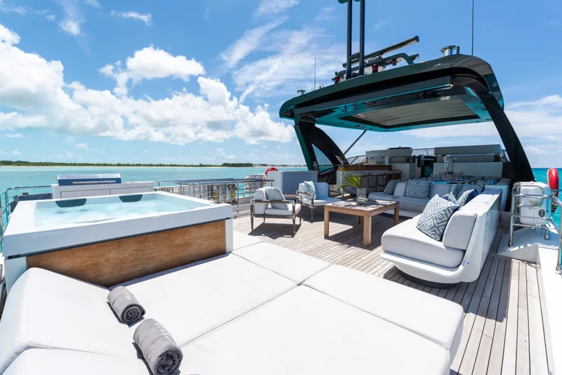 Slide: The Image of Luxurious 2023 Azimut Grande 32M yacht deck with jacuzzi and seating, under clear blue skies. - 24