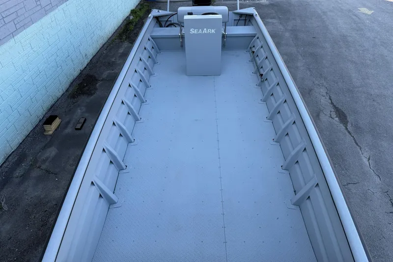 Slide: The Image of 2026 SeaArk 2472 Workhorse boat, spacious interior, sturdy design, parked on concrete surface. - 9