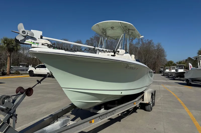 The Image of 2023 Sea Hunt Ultra 234 boat on trailer, parked outdoors under clear blue sky. - 1