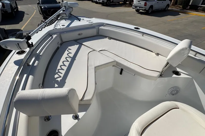 Slide: The Image of 2023 Sea Hunt Ultra 234 boat interior with cushioned seating and trolling motor. - 10