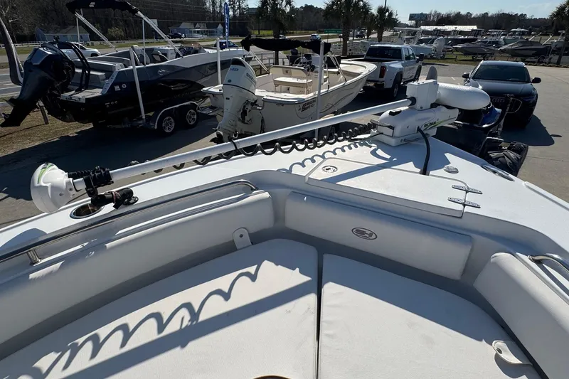 Slide: The Image of 2023 Sea Hunt Ultra 234 boat with trolling motor, docked among other boats. - 14