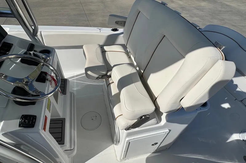 Slide: The Image of 2023 Sea Hunt Ultra 234 boat interior with steering wheel and cushioned seating. - 17