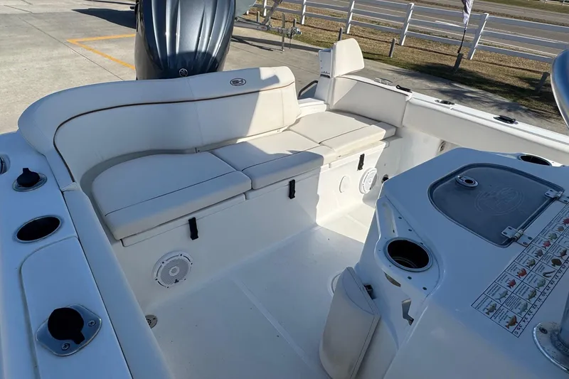 Slide: The Image of 2023 Sea Hunt Ultra 234 boat interior with white seating and fishing rod holders. - 22