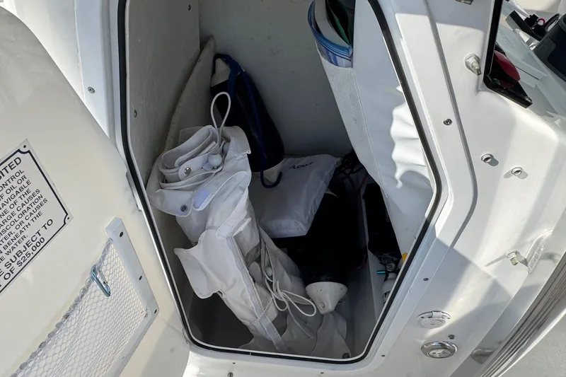 Slide: The Image of Storage compartment of 2023 Sea Hunt Ultra 234 boat with equipment and safety gear. - 9