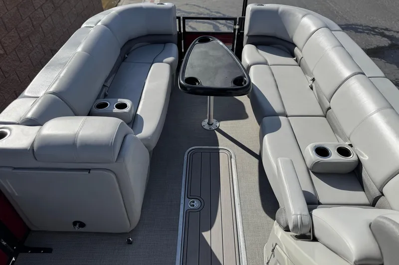 Slide: The Image of 2023 Regency 250 DL3 pontoon boat interior with plush seating and table. - 10
