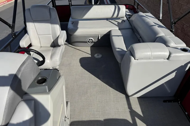 Slide: The Image of 2023 Regency 250 DL3 pontoon boat interior with plush seating and steering console. - 14