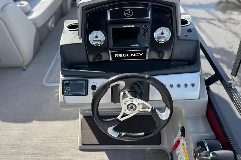 Slide: The Image of 2023 Regency 250 DL3 boat dashboard with steering wheel and navigation controls. - 29