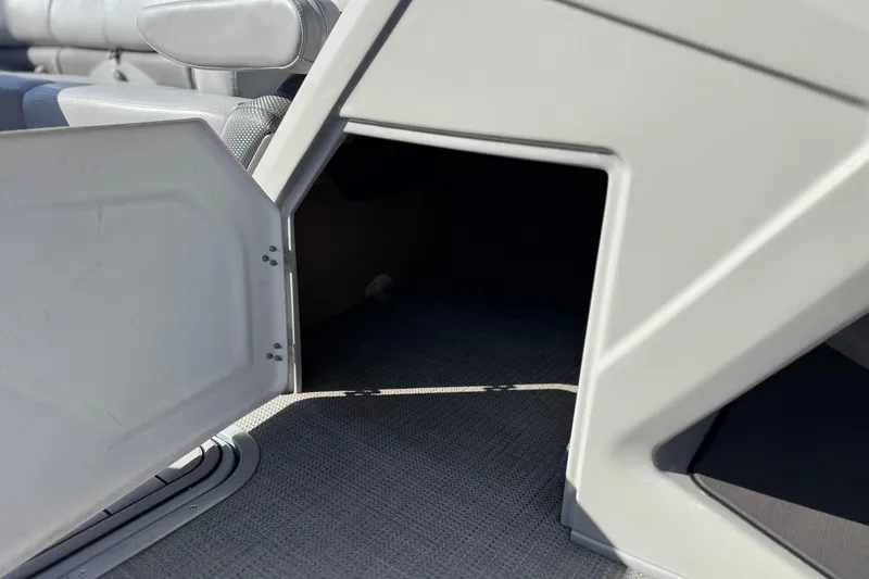 Slide: The Image of Open storage compartment on 2023 Regency 250 DL3 boat, featuring gray interior. - 32