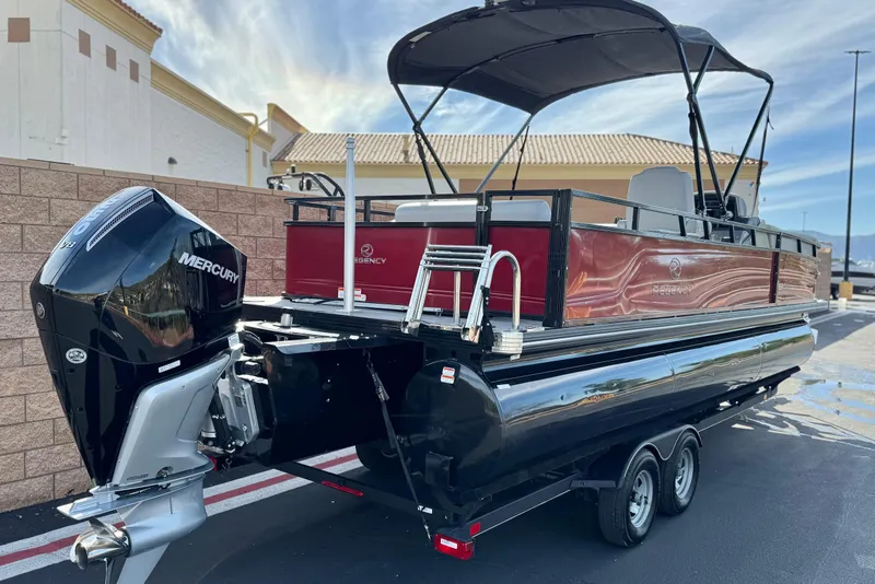 Slide: The Image of 2023 Regency 250 DL3 pontoon boat with Mercury outboard engine, parked outdoors. - 6