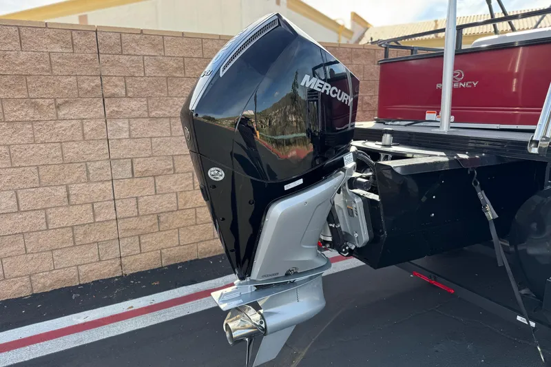 Slide: The Image of 2023 Regency 250 DL3 boat with Mercury outboard motor, parked near a brick wall. - 7