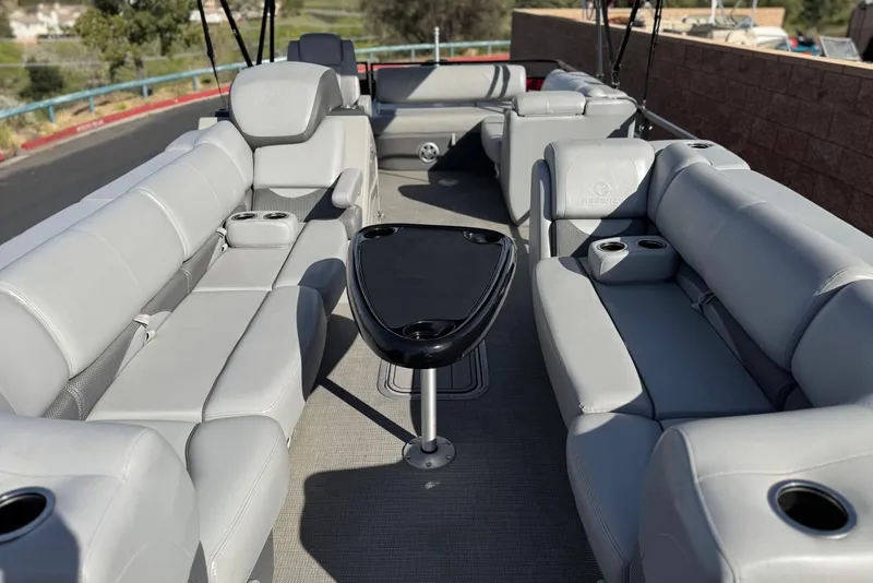 Slide: The Image of 2023 Regency 250 DL3 pontoon boat interior with luxurious seating and cup holders. - 9