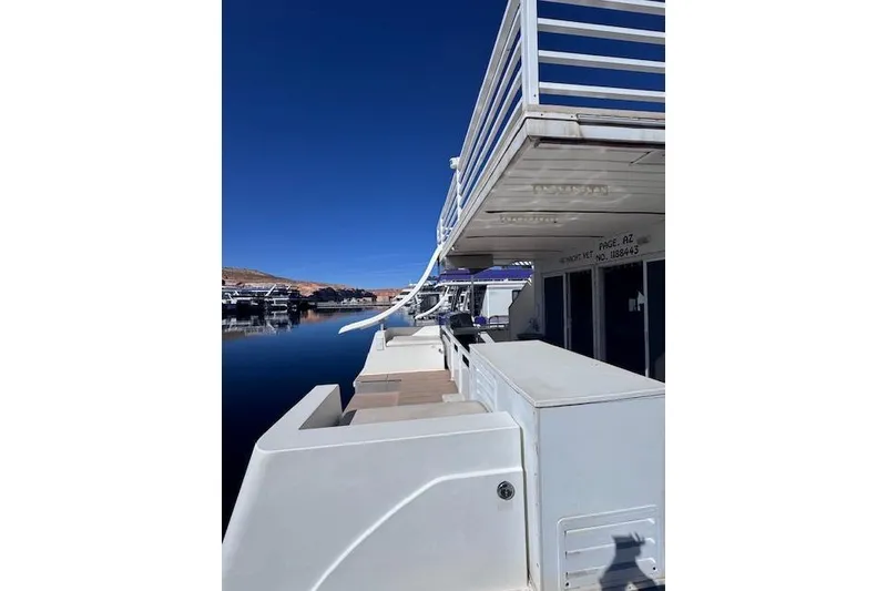 Slide: The Image of 2006 Destination Yachts houseboat with slide, docked on calm water under clear blue sky. - 14