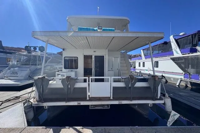 Slide: The Image of 2006 Destination Yachts houseboat docked, featuring spacious deck and modern amenities. - 2