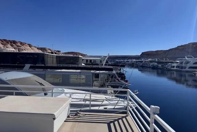 Slide: The Image of Houseboats docked in a serene marina, featuring a 2006 Destination Yachts model. - 21