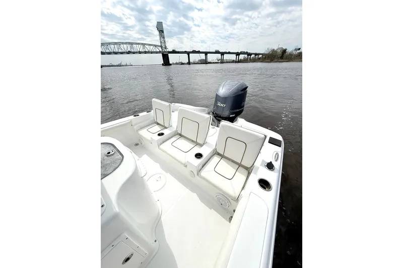 Slide: The Image of 2020 Sea Hunt BX 25 FS boat with seating, near a bridge on a cloudy day. - 14